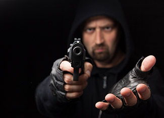 Armed Robber holding gun [Image © ijdema - Fotolia.com]